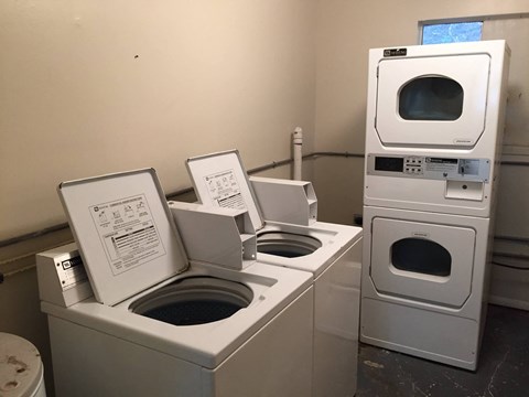 a group of washing machines and dryers in a room