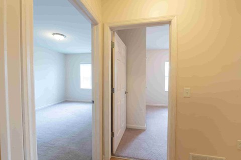 an empty living room with a door to a bedroom