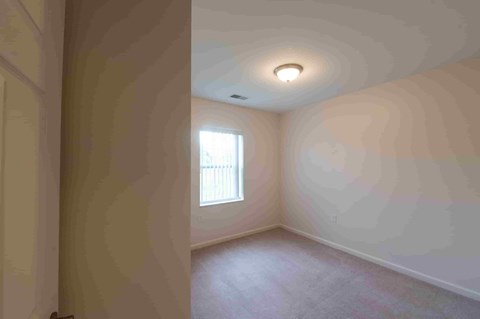 an empty room with white walls and a window