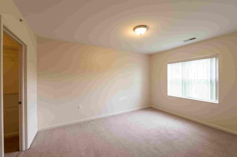 an empty room with white walls and a window