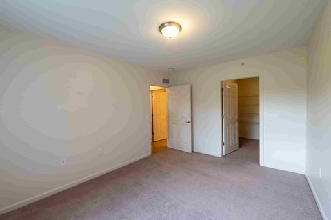 an empty living room with white walls and a door to a closet