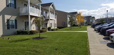 a row of houses with cars parked in front of them