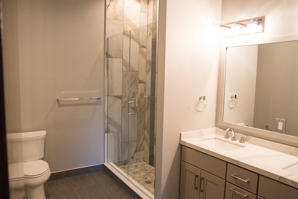 a bathroom with a shower and a sink and a toilet