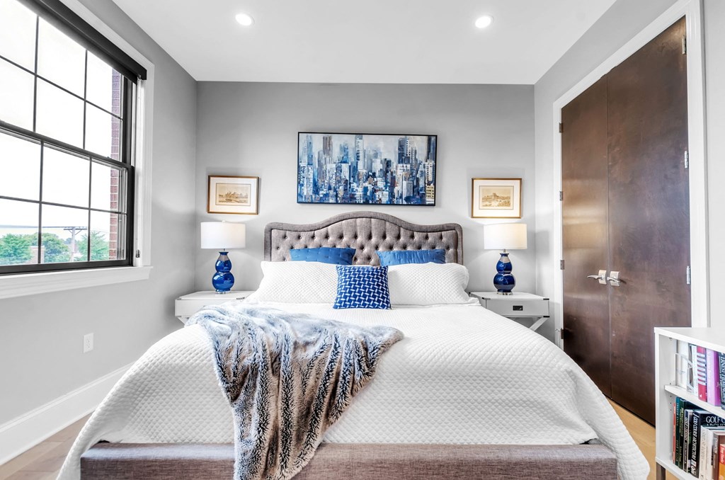 a bedroom with a bed and a large window