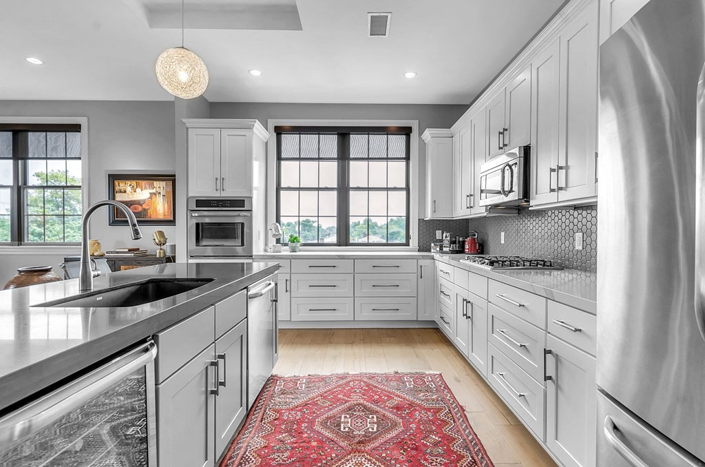 a white kitchen with a sink and a window