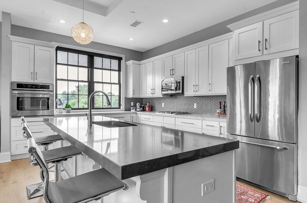 a large kitchen with stainless steel appliances and white cabinets