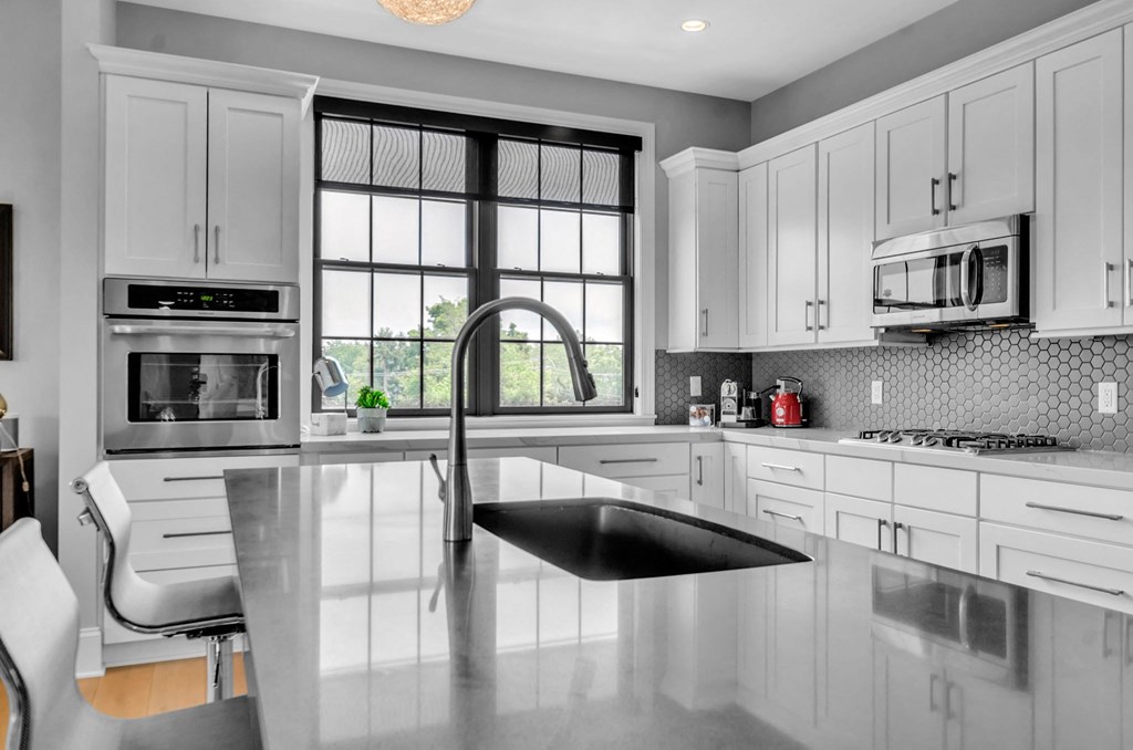 a kitchen with white cabinets and a black sink