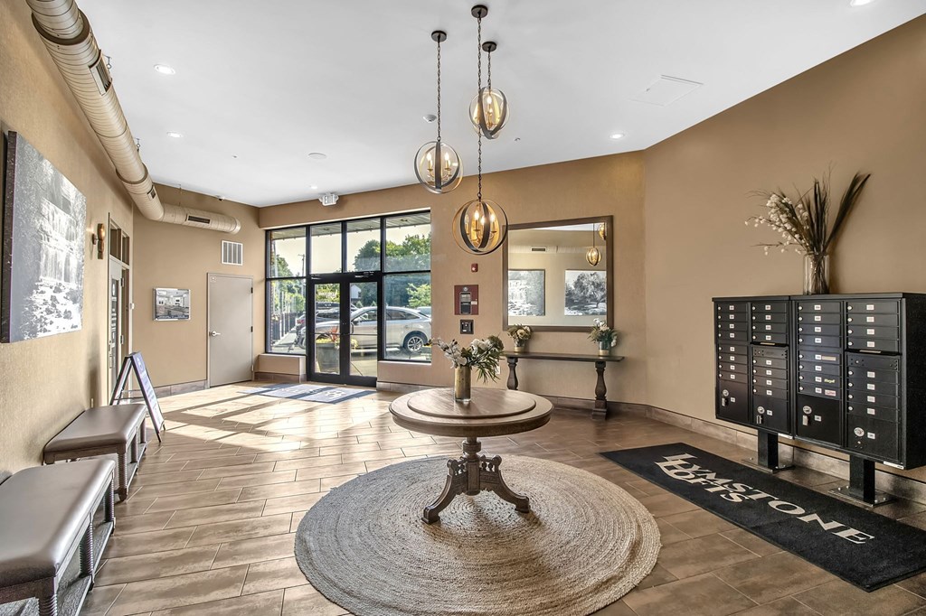 a lobby with a table and chairs in front of a glass door