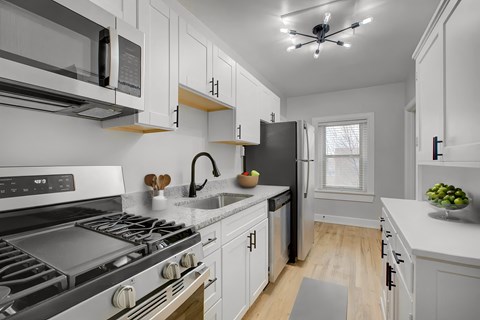 a kitchen with white cabinets and stainless steel appliances