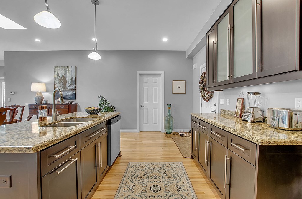 a kitchen with granite counter tops and wooden floors