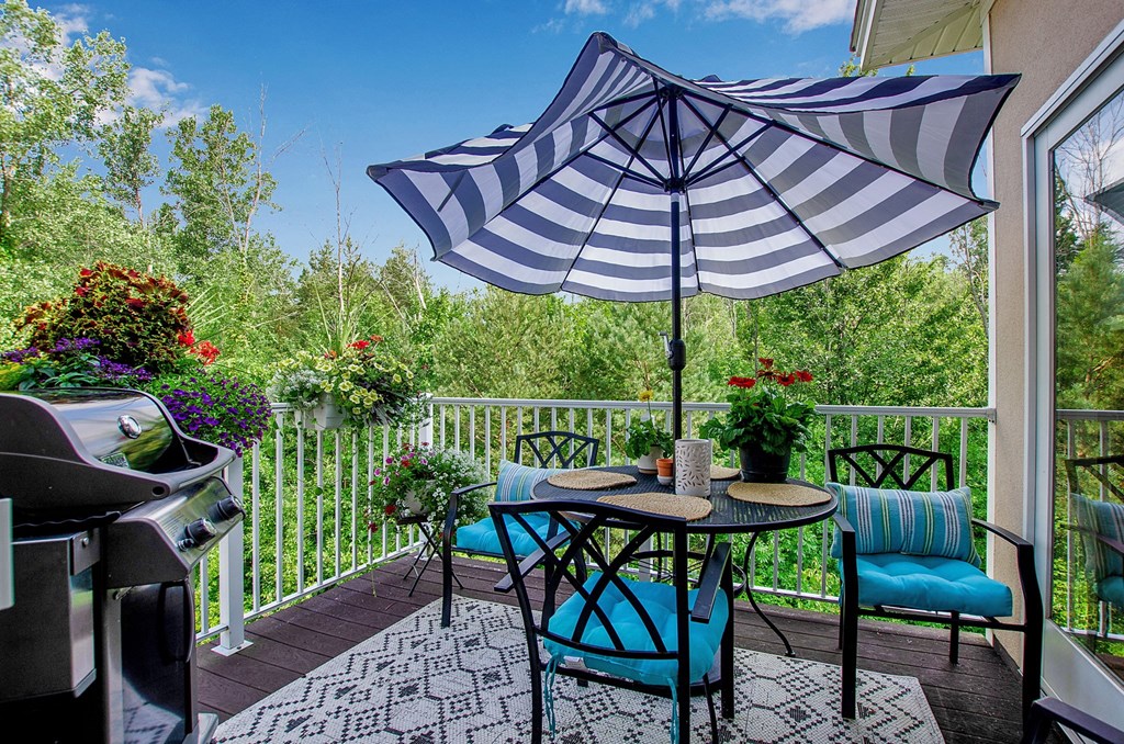a patio with an umbrella and a table and chairs