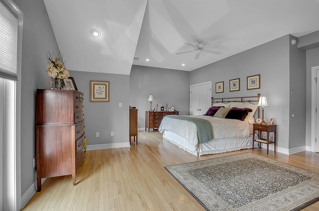 the master bedroom has a vaulted ceiling and hardwood floors
