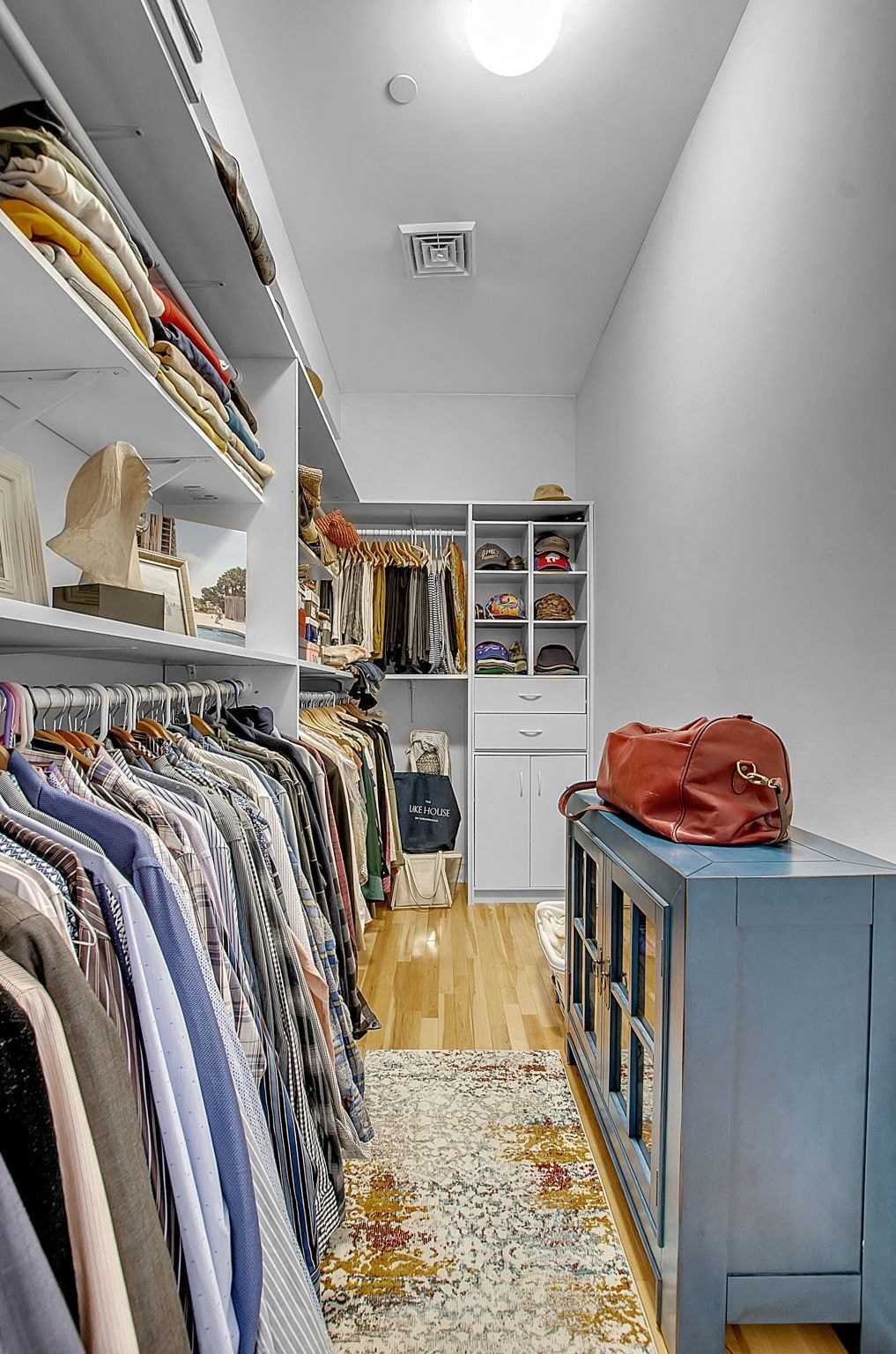 a walk in closet with a blue dresser