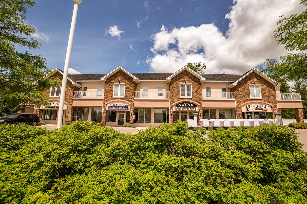 a large hotel building with bushes in front of it