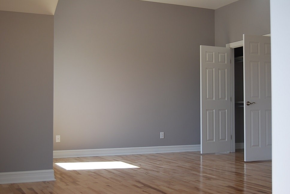 an empty room with a door and a wooden floor