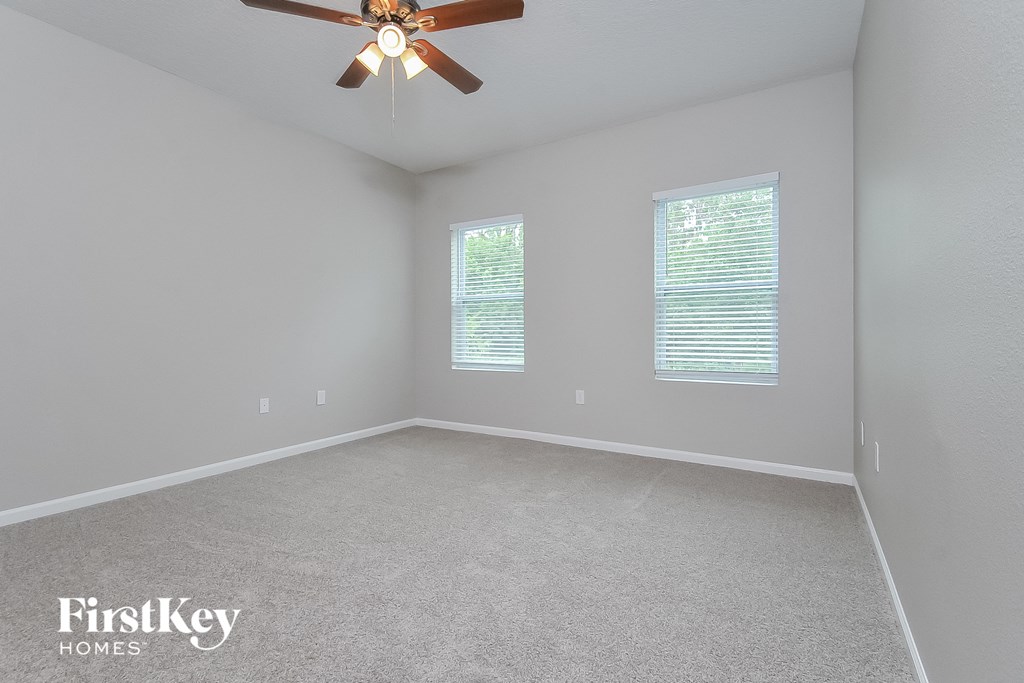 the living room of an empty house with a ceiling fan
