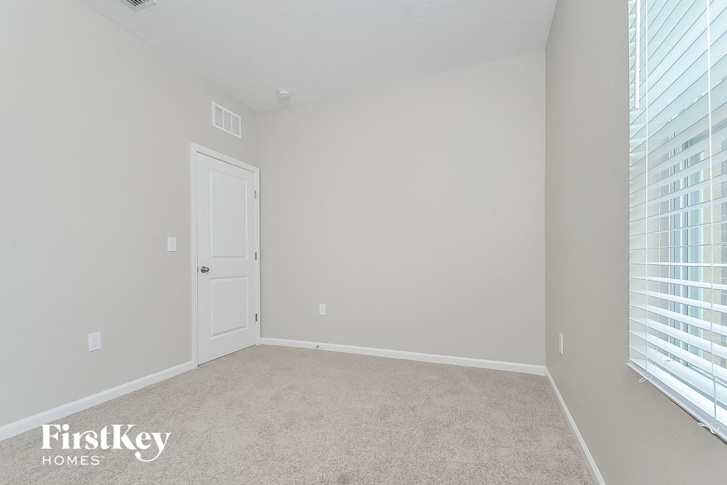 a bedroom with a carpeted floor and a white door