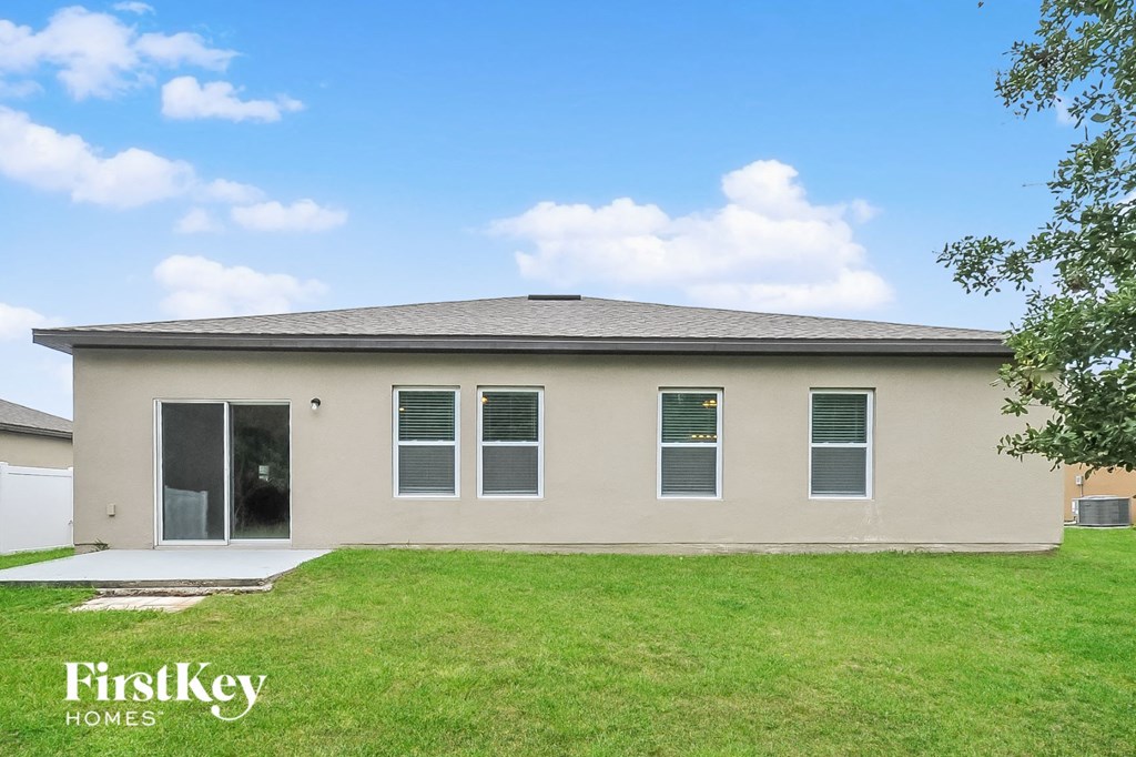 a beige house with a lawn and a blue sky
