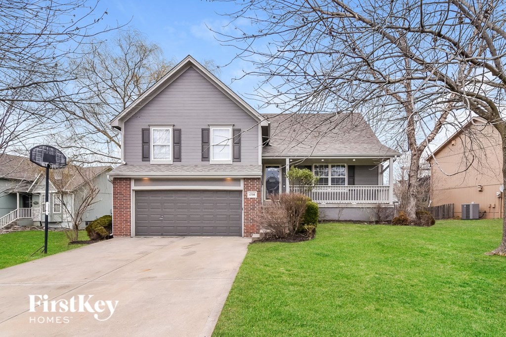 A house with a grey roof and a garage door.