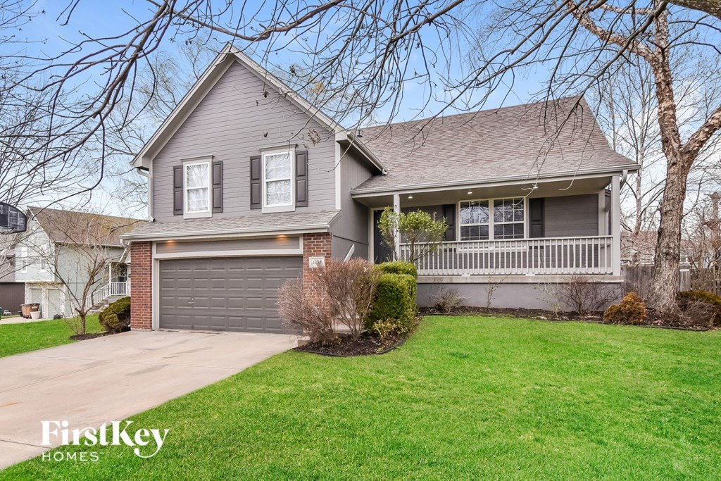 A house with a grey roof and a garage door.