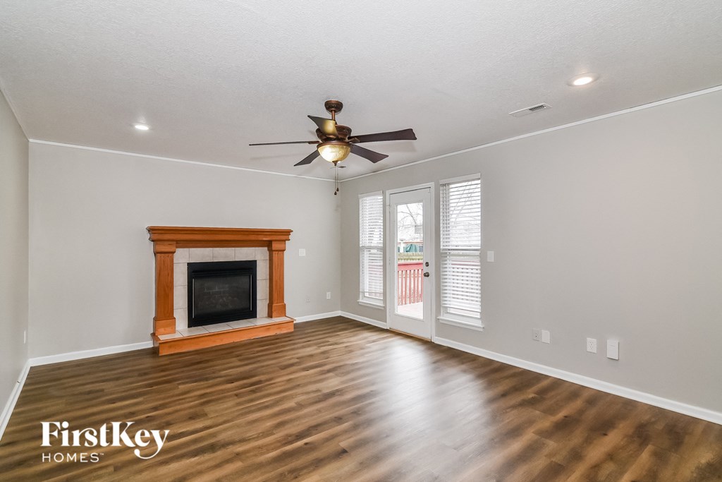 A room with a fireplace and a ceiling fan.