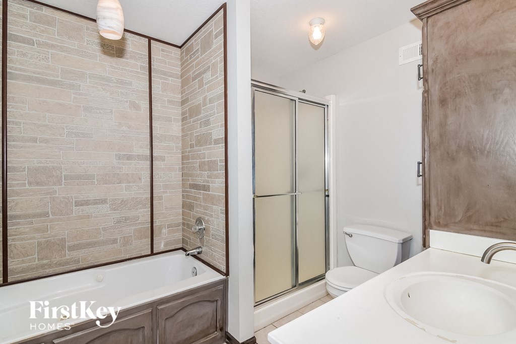 A bathroom with a tub, toilet, and sink.