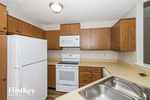 A kitchen with wooden cabinets and a white refrigerator.