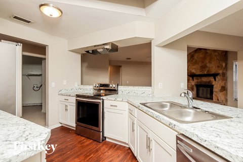 a kitchen with white cabinets and granite counter tops and a sink
