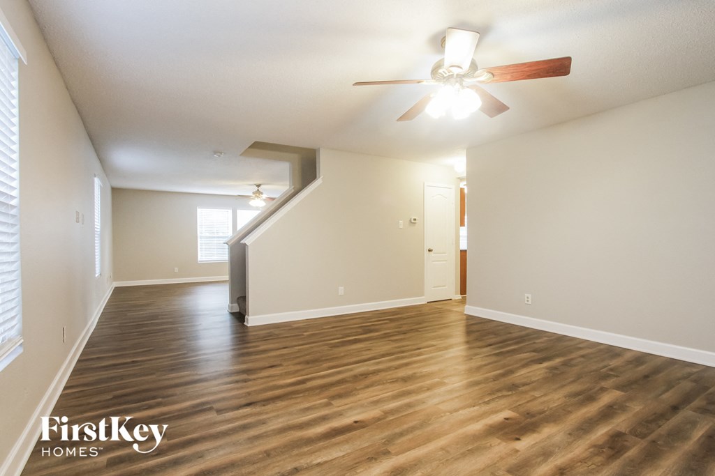 the living room and dining room with hardwood flooring and a ceiling fan