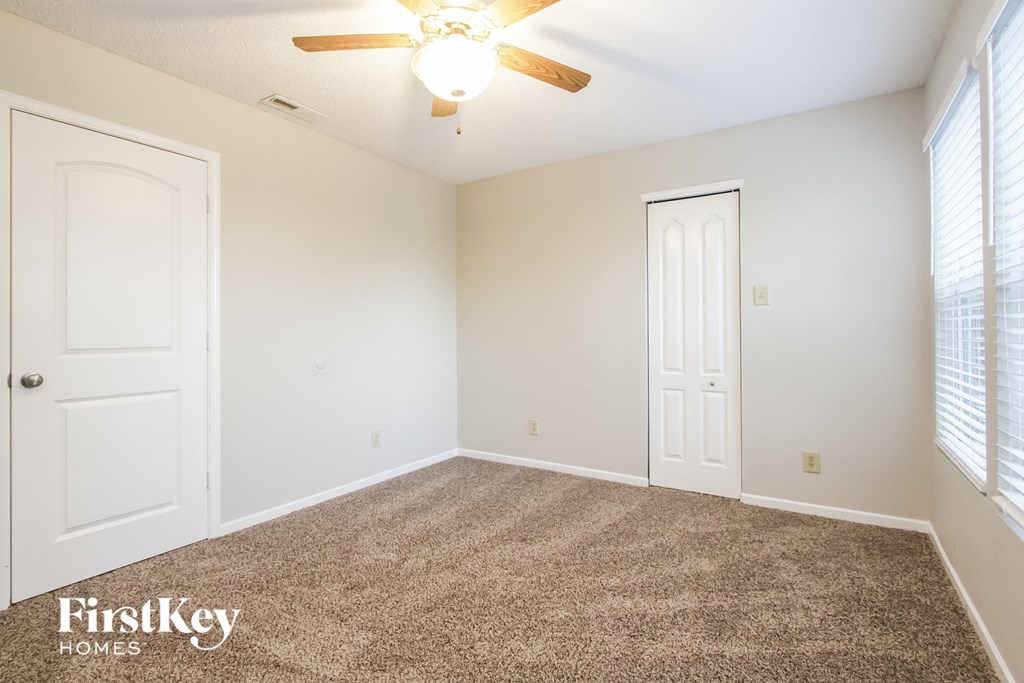 a bedroom with a carpeted floor and a ceiling fan