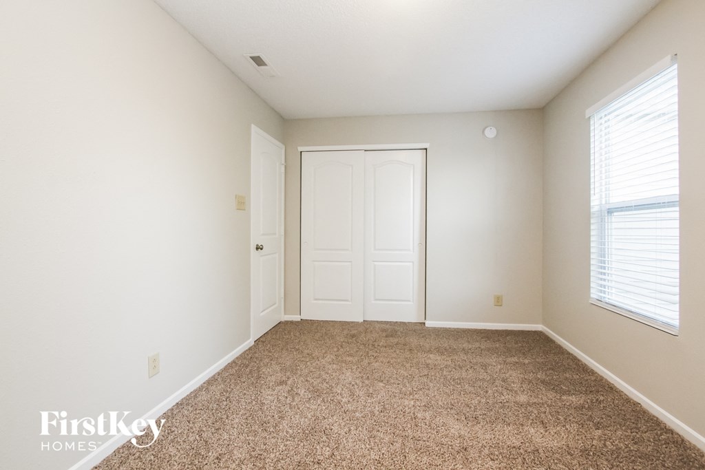 a bedroom with a carpeted floor and a white door