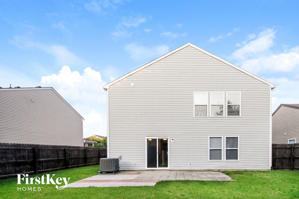 the outside of a white house with a yard and grass