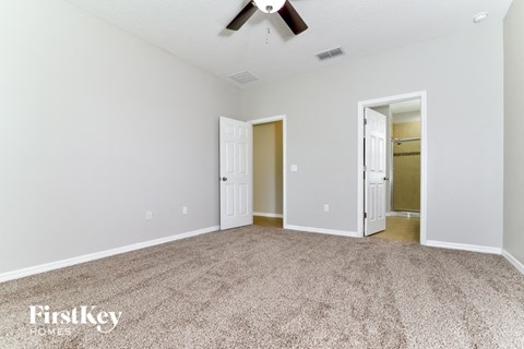 a living room with a carpet and a ceiling fan