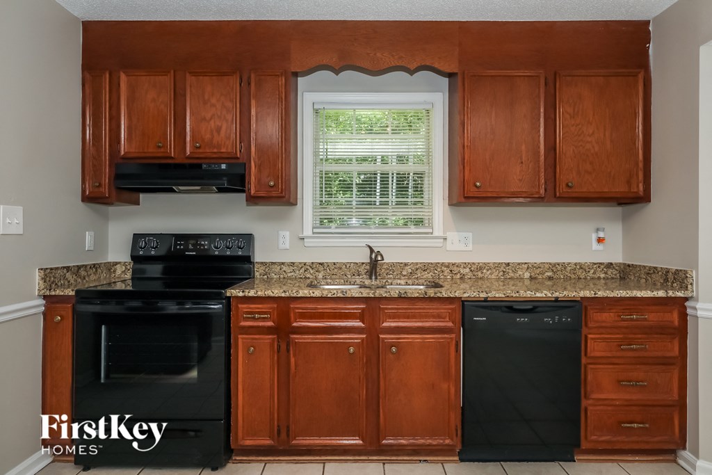 A kitchen with wooden cabinets and black appliances.
