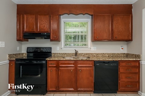 A kitchen with wooden cabinets and black appliances.