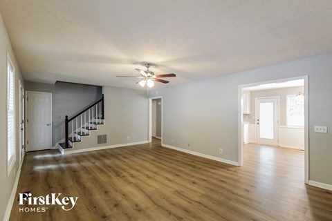 the living room and dining room with hardwood flooring and a ceiling fan