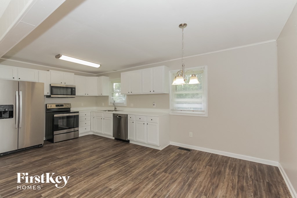 a kitchen with white cabinets and stainless steel appliances