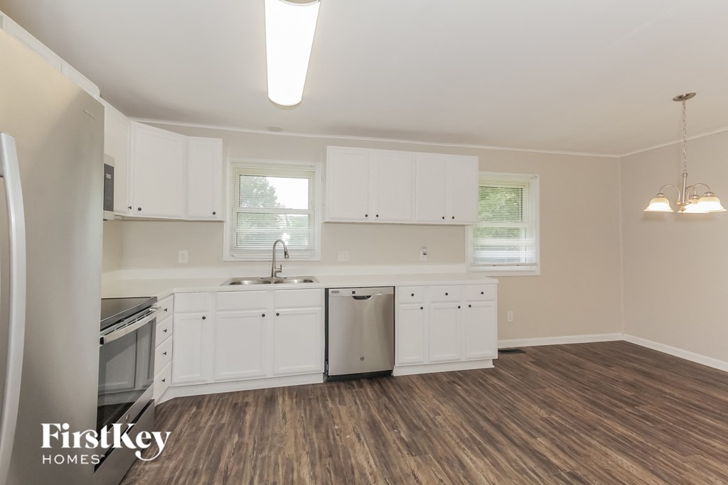 the kitchen of a home with white cabinets and stainless steel appliances