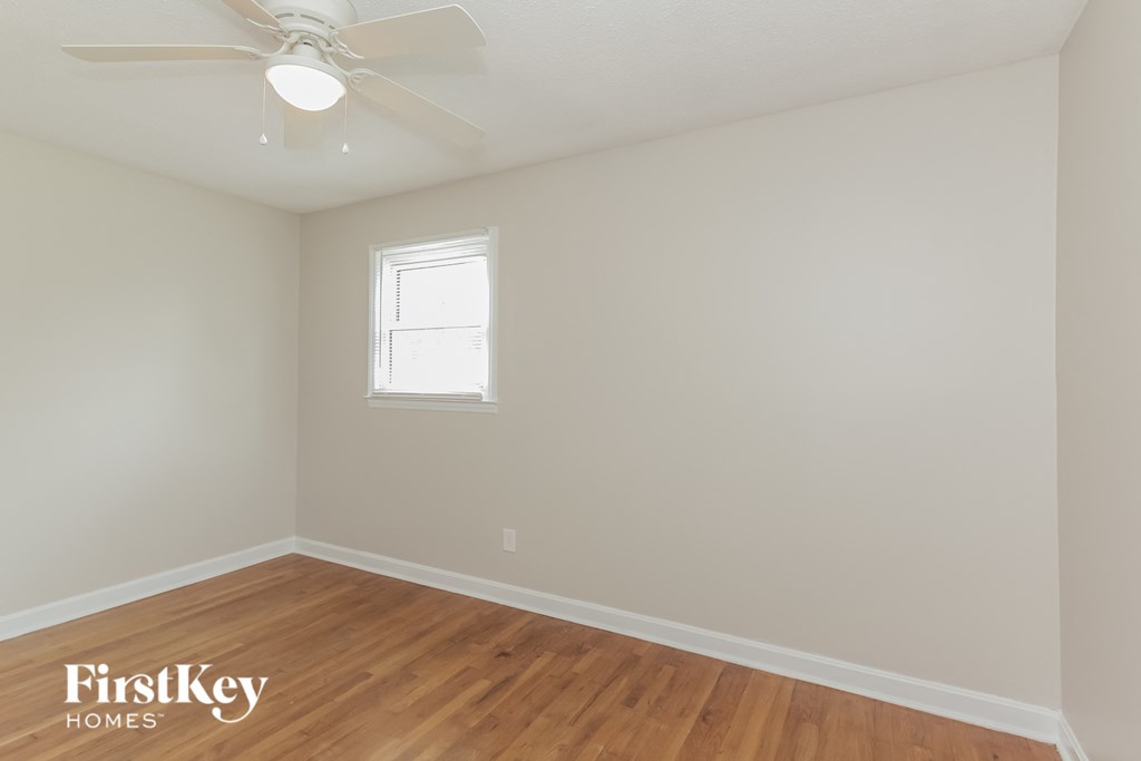 the bedroom with hardwood flooring and a ceiling fan
