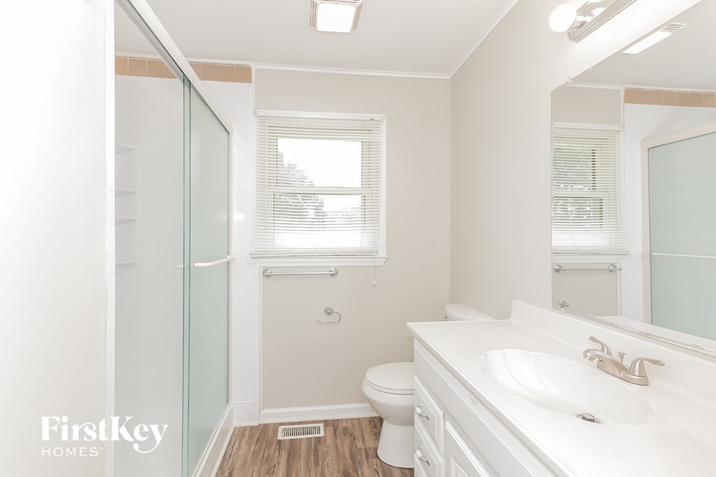 a bathroom with a shower toilet and sink and a mirror