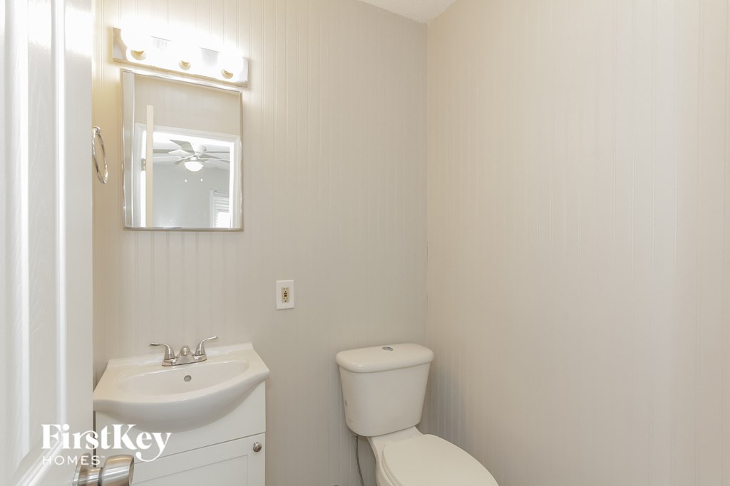 a bathroom with a toilet and a sink and a mirror