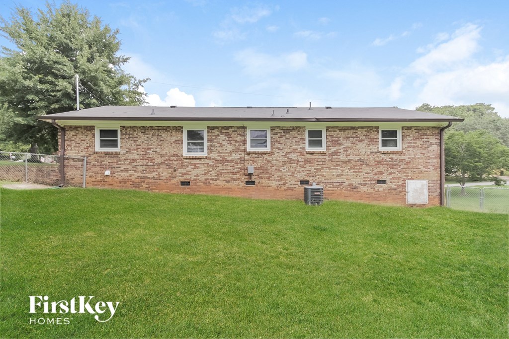 a brick house with a grassy yard in front of it