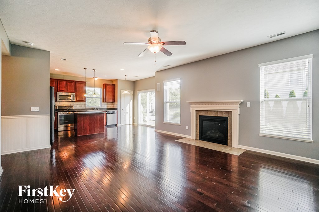 an empty living room with wood floors and a fireplace
