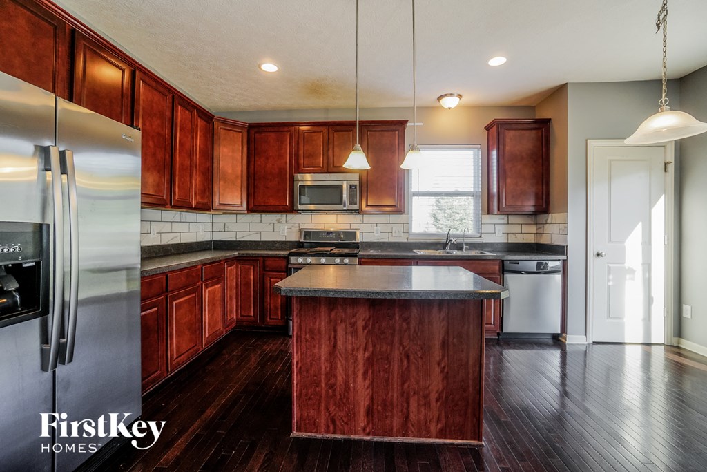 an updated kitchen with wood cabinets and stainless steel appliances