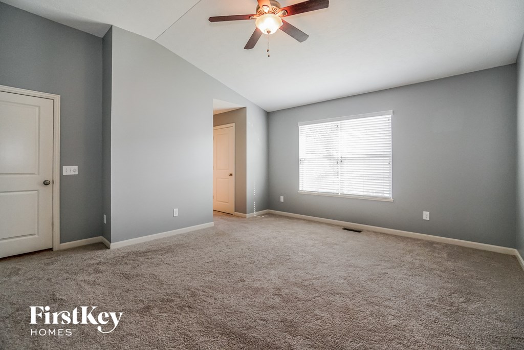 an empty room with a ceiling fan and a door to a closet