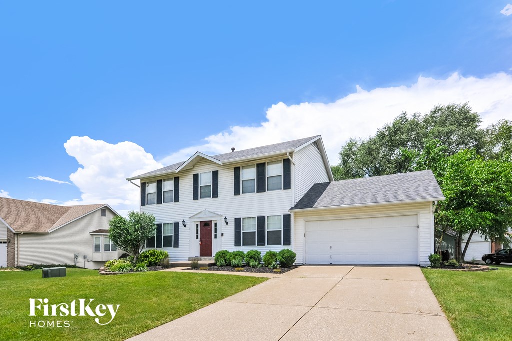 a white house with a lawn and a blue sky