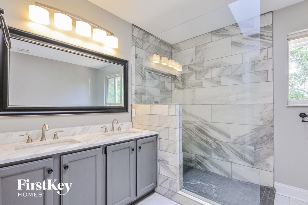 the master bathroom has a large shower and dual sinks