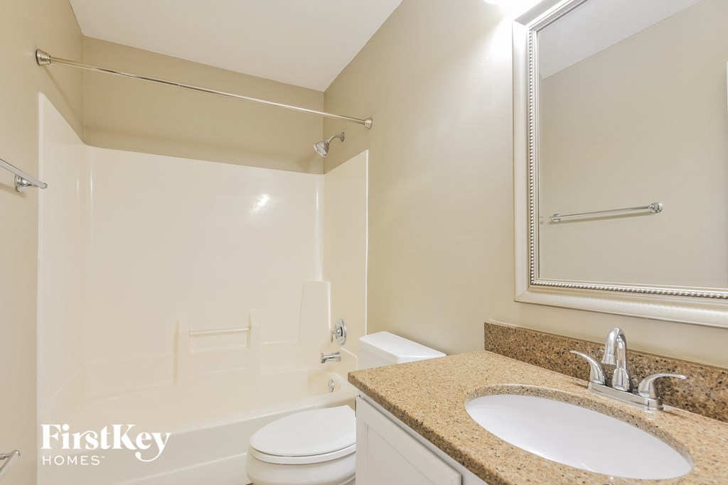a bathroom with a shower toilet and sink and a mirror
