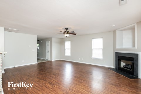 a living room with a fireplace and a ceiling fan
