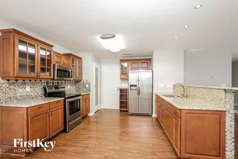 a kitchen with wooden cabinets and granite counter tops and stainless steel appliances